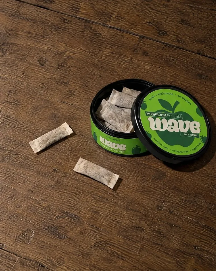 Otevřená dóza WAVE se sáčky uvnitř a dvěma sáčky vedle ní.